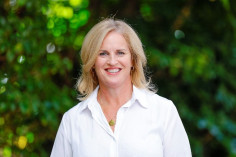 A head and shoulders photo of Hon. Louise Upston. She is wearing a white shirt, and there are trees in the background.