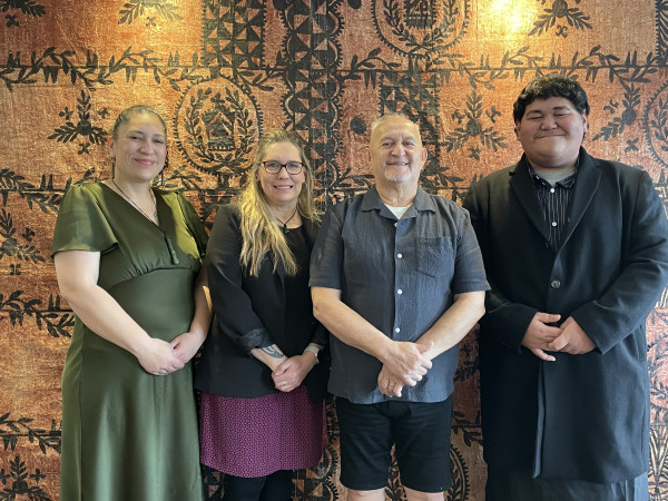 The 4 Te Rōpū Kaitiaki members stand in front of a tapa cloth.